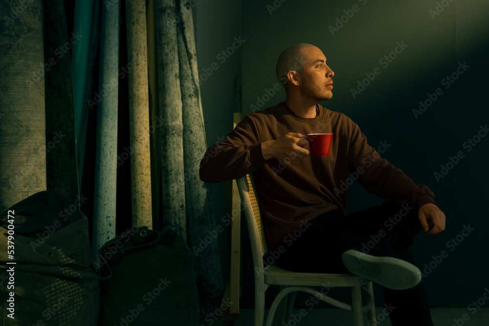 man sitting on chair with a red coffee cup