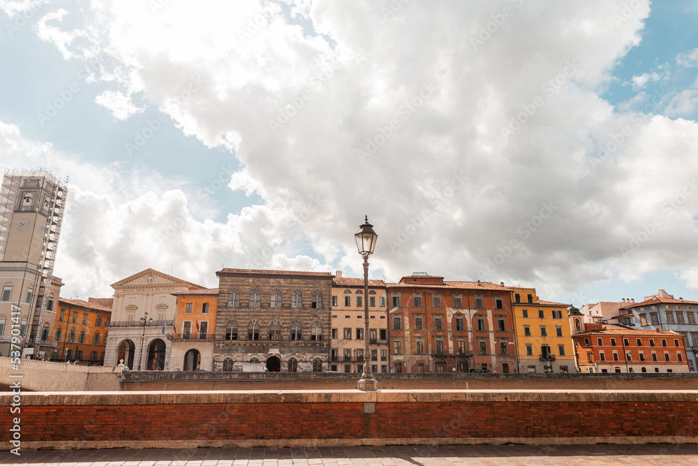 Obraz premium Beautiful vintage European town with old houses on a bridge road along the river in Pisa, Italy