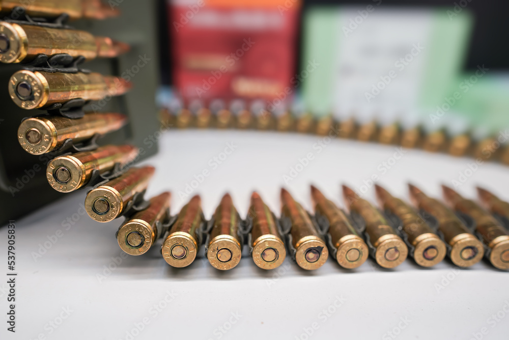 Bandolier or ammo belt with machine gun rounds at display at weapons fair, closeup detail Bandolier or ammo belt with machine gun rounds at display at weapons fair, closeup detail