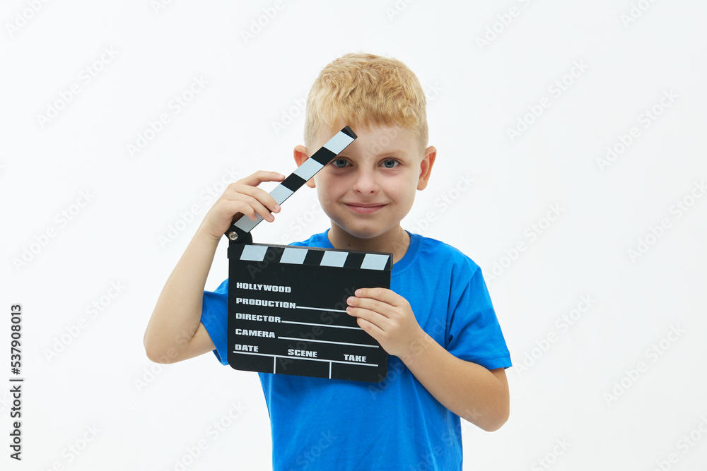 Funny smiling child boy hold film making clapperboard isolated on white background. Studio portrait. Childhood lifestyle concept. Copy space for text Funny smiling child boy hold film making clapperboard isolated on white background. Studio portrait. Childhood lifestyle concept. Copy space for text