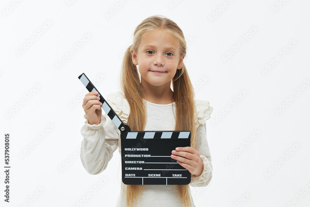 Funny smiling child girl in cool eyeglasses hold film making clapperboard isolated on white background. Studio portrait. Childhood lifestyle concept. Copy space for text Funny smiling child girl in cool eyeglasses hold film making clapperboard isolated on white background. Studio portrait. Childhood lifestyle concept. Copy space for text