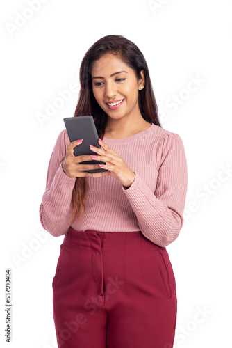 Cheerful Indian young woman using smart phone.