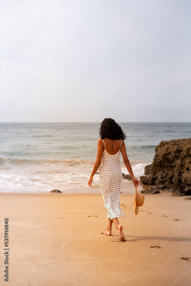 Unrecognisable lonely woman walking on the beach Unrecognisable lonely woman walking on the beach