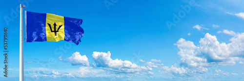 Quadro su tela Barbados flag waving on a blue sky in beautiful clouds - Horizontal banner
