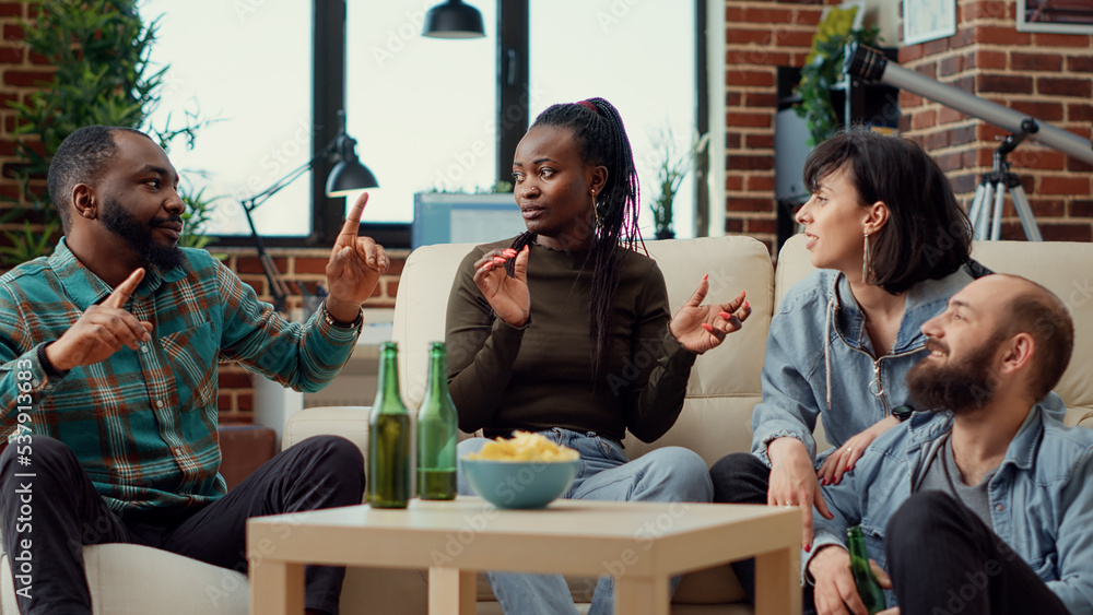 Happy people laughing and having conversation at hangout, drinking beer and eating snacks. Group of cheerful friends having fun together, talking about friendship memories. Handheld shot. Happy people laughing and having conversation at hangout, drinking beer and eating snacks. Group of cheerful friends having fun together, talking about friendship memories. Handheld shot.