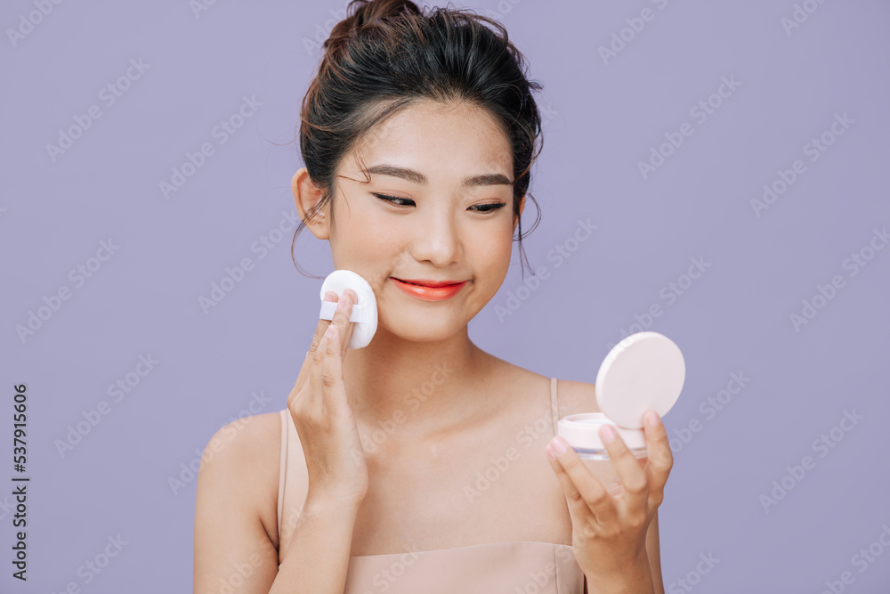 young beautiful woman applying compact powder on her face. young beautiful woman applying compact powder on her face.
