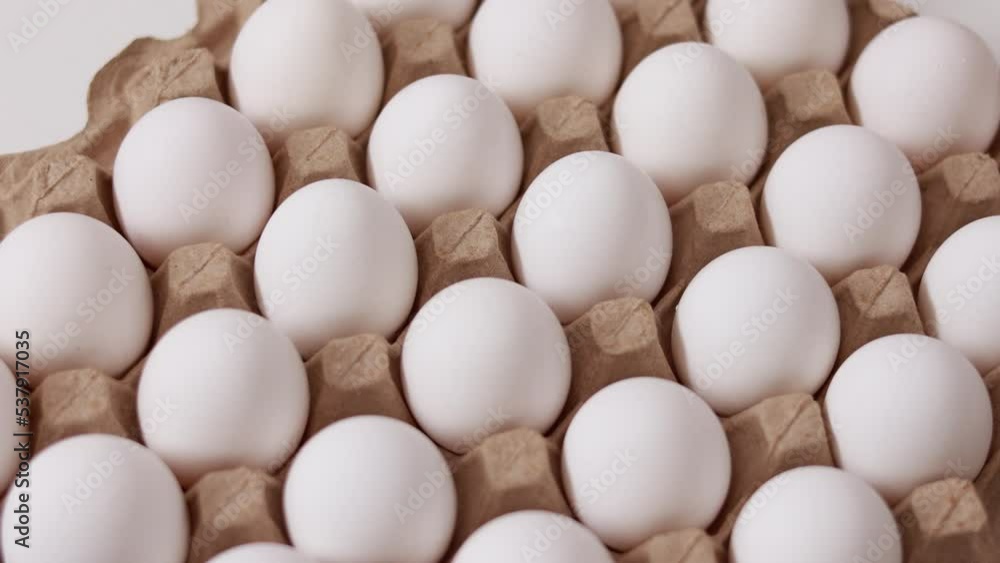 White chicken eggs in a cardboard box. Fresh raw eggs in a paper egg container for store and shop. egg tray with eggs on white table background. Top view. preparation to easter holiday. White chicken eggs in a cardboard box. Fresh raw eggs in a paper egg container for store and shop. egg tray with eggs on white table background. Top view. preparation to easter holiday.