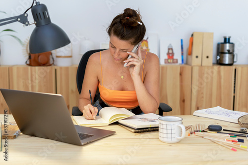 Illustrator woman calling by phone at office  photo