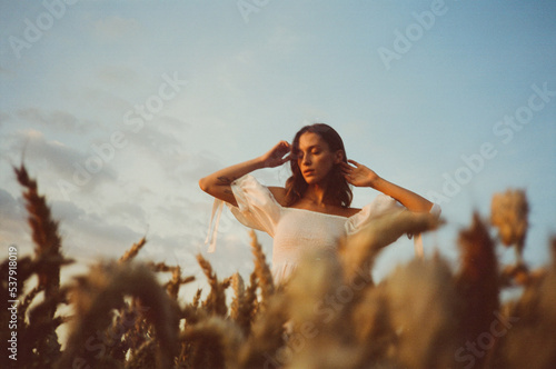 Girl feeling relaxed among crop field  photo