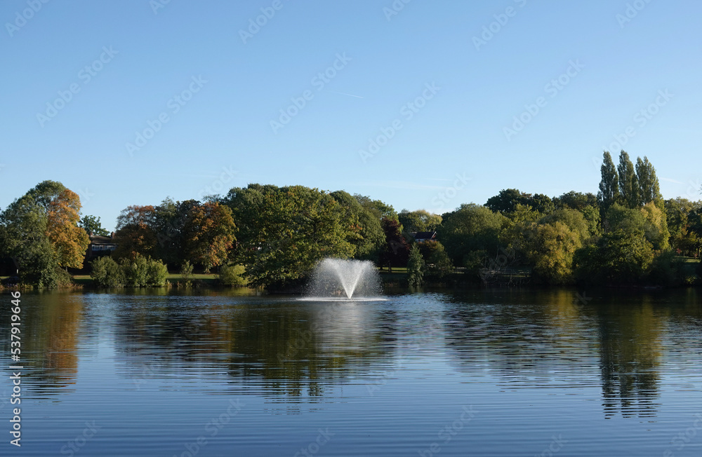 A tranquil view across the lake and fountain at Lake Meadows park, Billericay, Essex, UK. A tranquil view across the lake and fountain at Lake Meadows park, Billericay, Essex, UK.