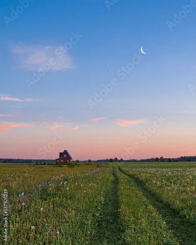 Lonely house in a field at sunset