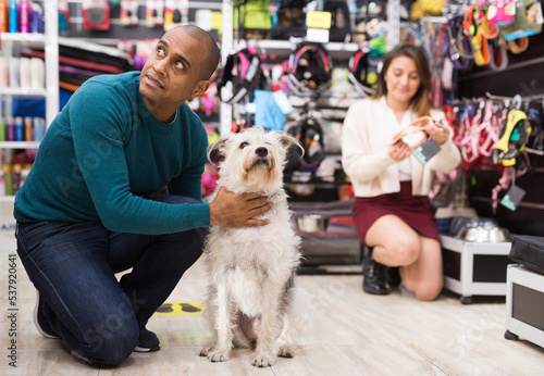 Portrait of happy man visiting pet supplies store with her cute dog