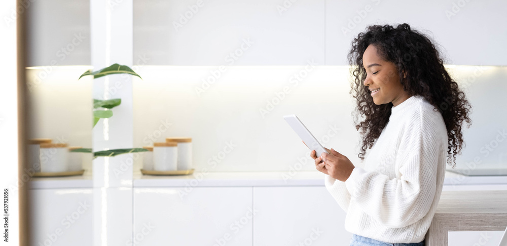 Banner African American Girl using iPad tablet at home pressing finger, reading social media internet, typing text or shopping online. Freelancer Remotely working online at home Banner African American Girl using iPad tablet at home pressing finger, reading social media internet, typing text or shopping online. Freelancer Remotely working online at home