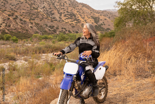 Mature woman outdoor on a dirtbike photo