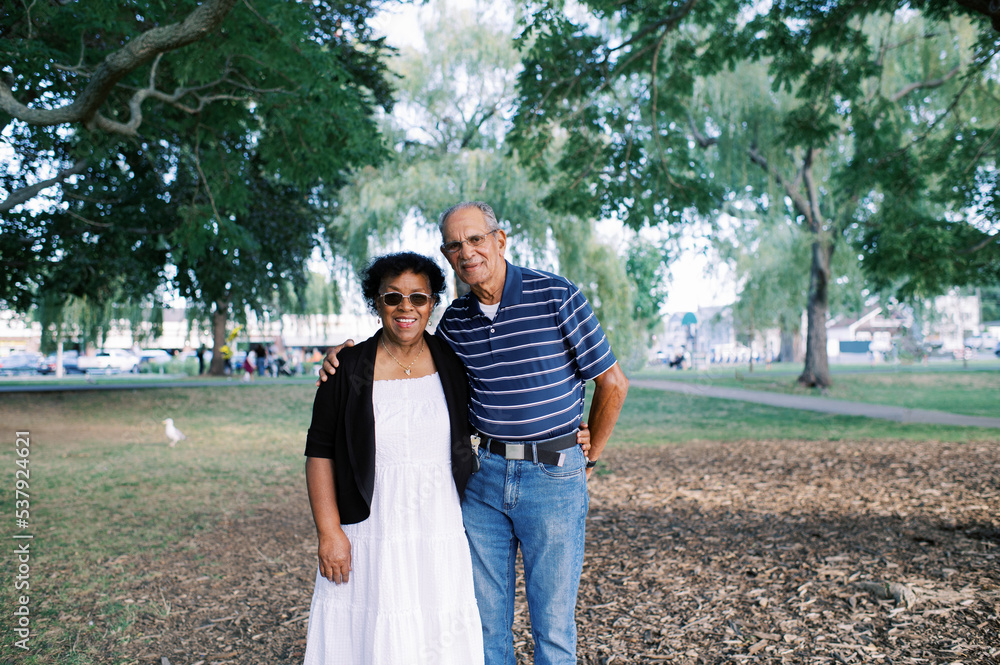 happy smiling senior couple standing under a tree happy smiling senior couple standing under a tree