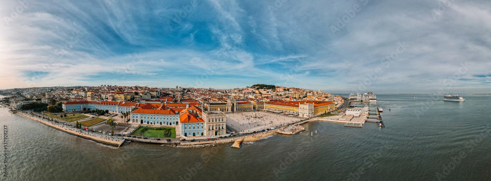 Aerial panoramic view of pedestrians at Praca do Comercio in Lisbon, Portugal with St. George Castle in the background as well as other Lisbon landmarks