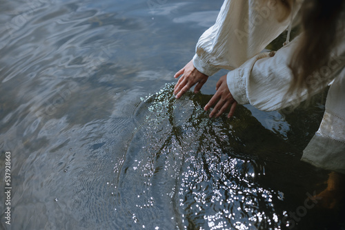 
female hands on the surface of the water