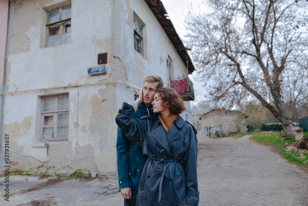 man and woman hugging near the old house man and woman hugging near the old house