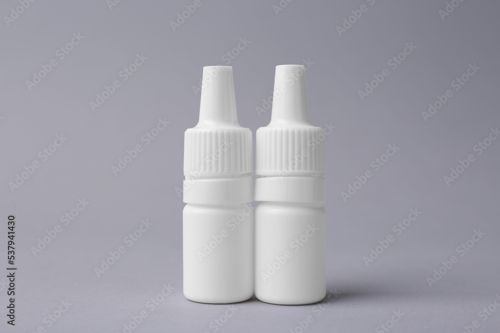 Bottles of medical drops on grey background Bottles of medical drops on grey background