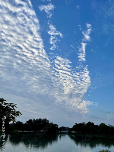 The river reflected the blue sky decorated with white clouds.