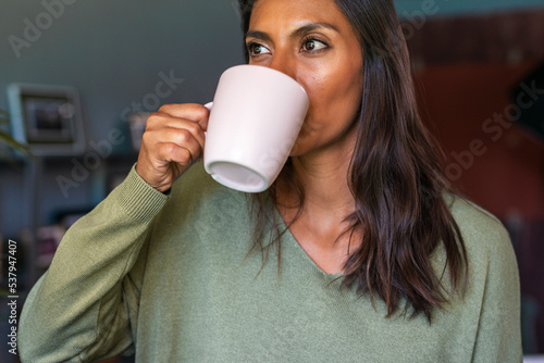 Authentic woman having coffe and looking out the window photo