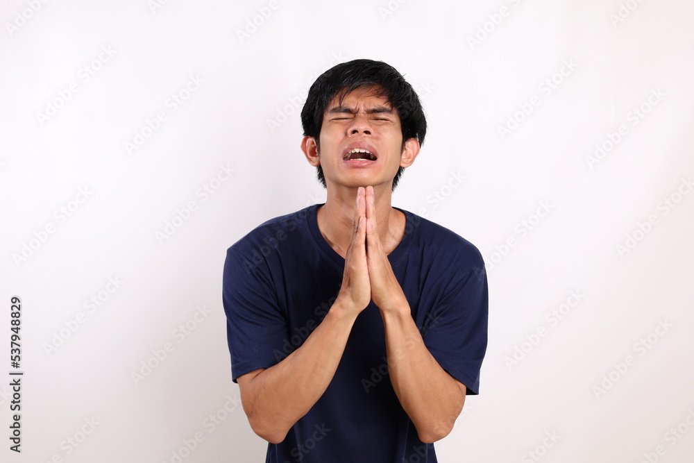 Portrait of young asian man standing with begging or asking gesture. Isolated on white background Portrait of young asian man standing with begging or asking gesture. Isolated on white background