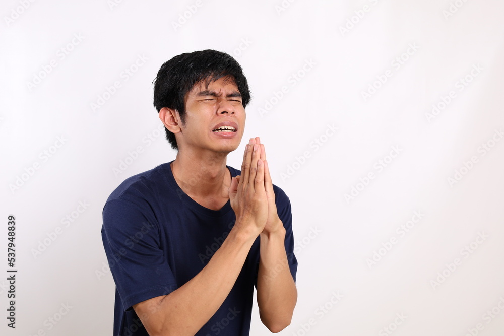 Portrait of young asian man standing with begging or asking gesture. Isolated on white background Portrait of young asian man standing with begging or asking gesture. Isolated on white background