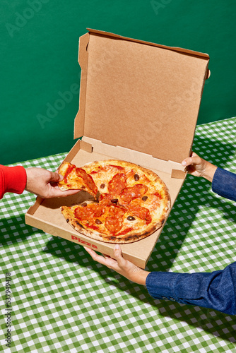 Anonymous person taking slice of pizza