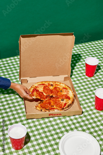 Anonymous person taking slice of pizza