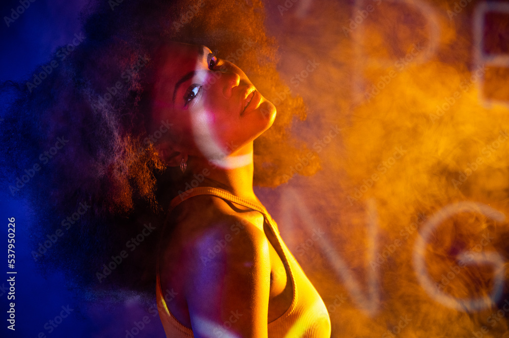 African American model under colorful neon illumination African American model under colorful neon illumination