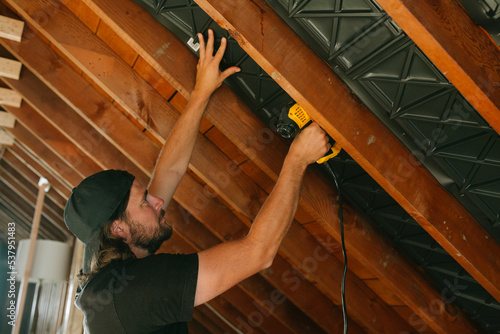 man uses nail gun in construction home