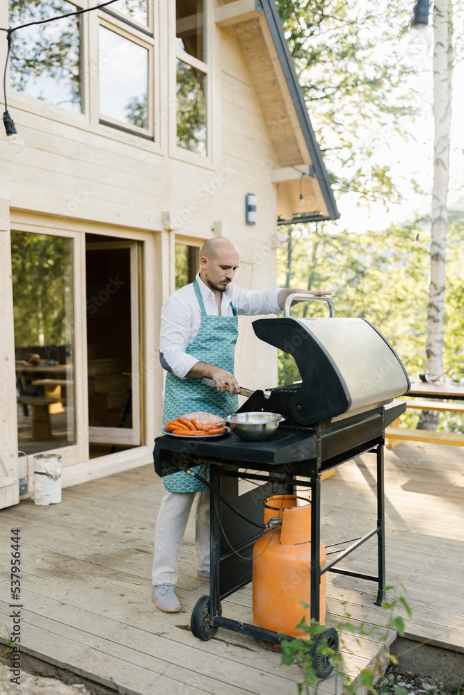 Man Preparing Barbecue Outdoors Man Preparing Barbecue Outdoors