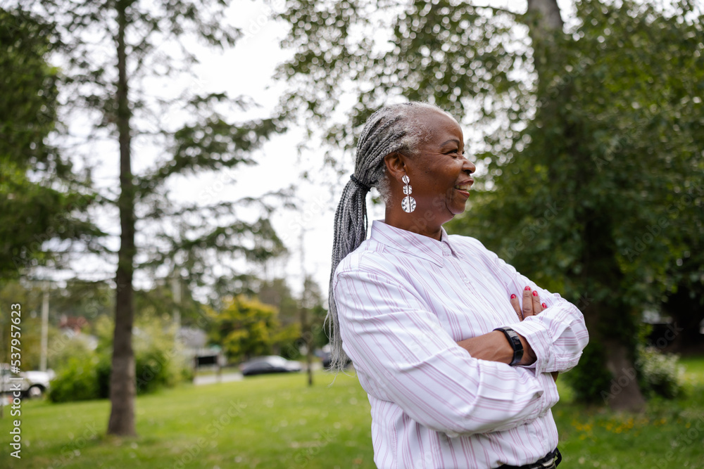 Mature, smiling black woman with dreadlocks outside in nature. Mature, smiling black woman with dreadlocks outside in nature.