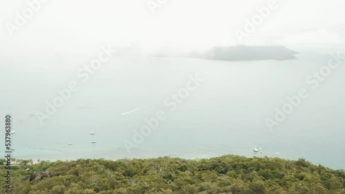 Drone aerial in the cloud over tropical Fitzroy island with blue water in Queensland Australia photo