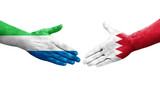 Handshake between Bahrain and Sierra Leone flags painted on hands, isolated transparent image.