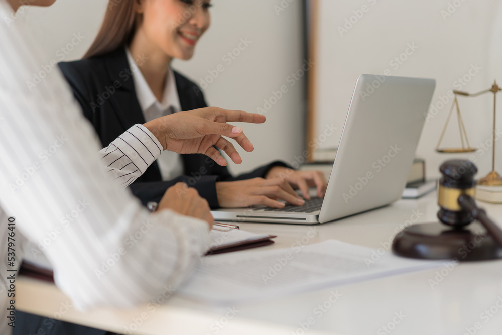 Legal and justice concept, Two female lawyers discussing about contract and typing data on laptop Legal and justice concept, Two female lawyers discussing about contract and typing data on laptop