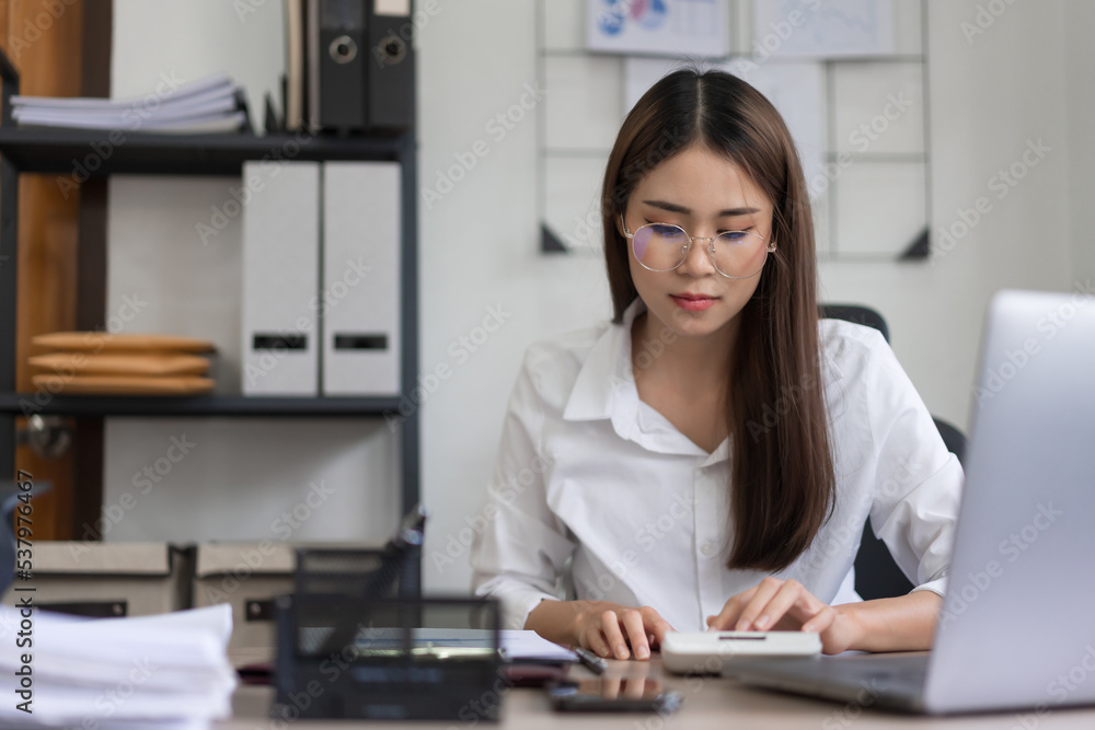Business concept, Businesswoman reading document and use calculator to calculate investment budget Business concept, Businesswoman reading document and use calculator to calculate investment budget