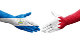 Handshake between Bahrain and Nicaragua flags painted on hands, isolated transparent image.