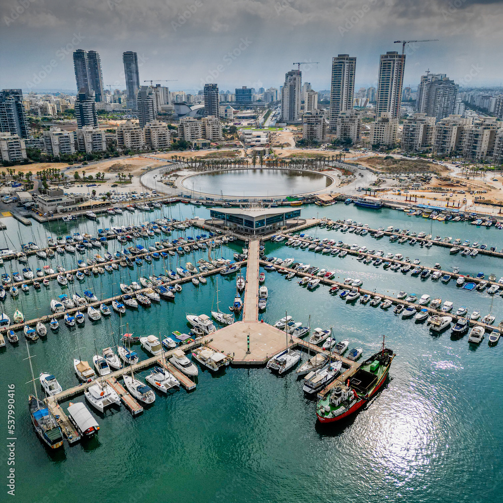 Obraz premium Ashdod city complete beautiful panoramic aerial view from the sea showing it modern marina symmetric open landscape and sky scrapers in the distance with overcast skies