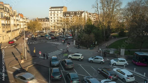 High angle shot of roads passing by along road crossing  beside park Jardin Darcy, Dijon, France during evening in timelapse. photo