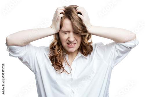 Young woman in stress holding her head. Pretty brown-haired woman in a white shirt. Isolated on white background.