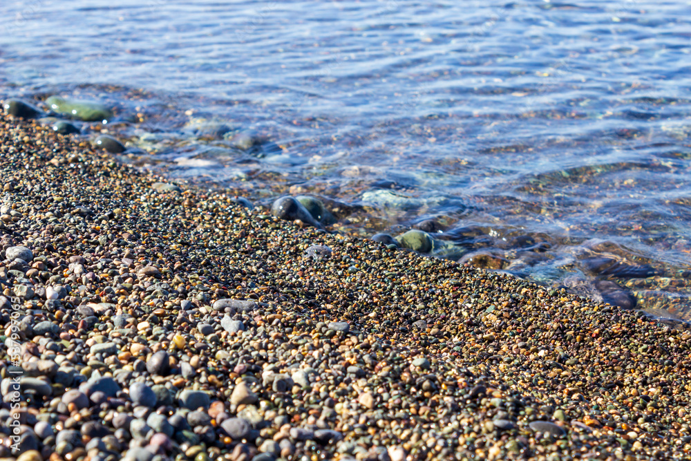 Coast. Pebble. Diagonal. Clear sea water. No waves.