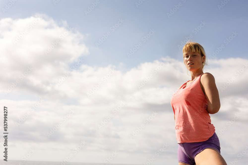 Beautiful young woman practising yoga outside. Fit woman doing stretching exercises at the beach Beautiful young woman practising yoga outside. Fit woman doing stretching exercises at the beach