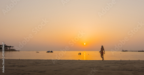 woman walking for snorkeling after a warm sunrise at the beach in egypt panorama view