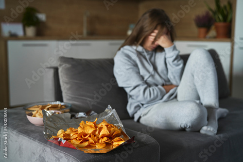 Caucasian woman has a problem with bulimic and sitting at the couch at home photo