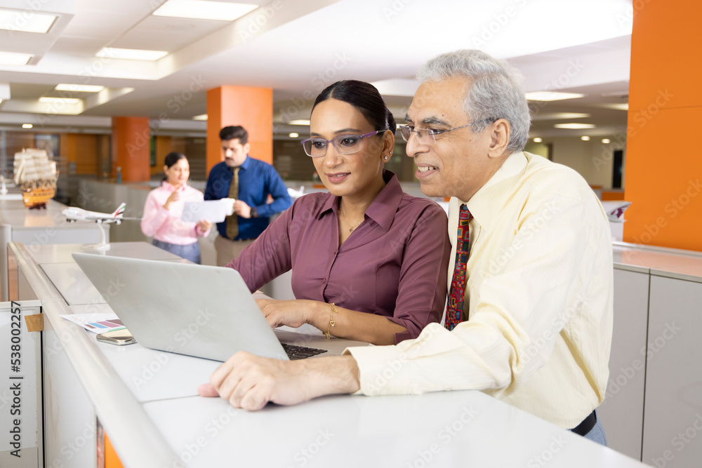 Obraz premium Senior businessman with woman using laptop at office.