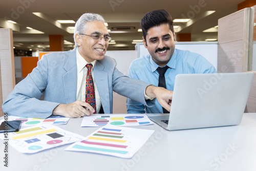 Man with old father using laptop while planning budget finance in office. © G-images