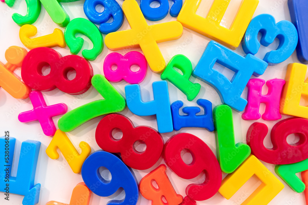 Fototapeta premium Multi-colored plastic letters on a white background. Fridge magnets in the form of letters