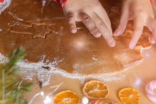 Closeup children's hands make Christmas ginger cookies.