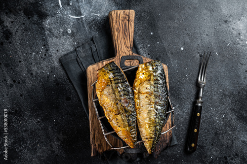 Grilled mackerel fish fillet on a grill. Black background. Top view